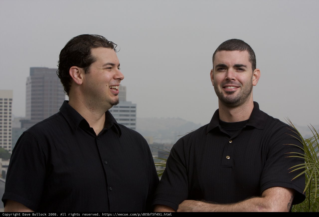 Smiling Men in Front of Skyscraper