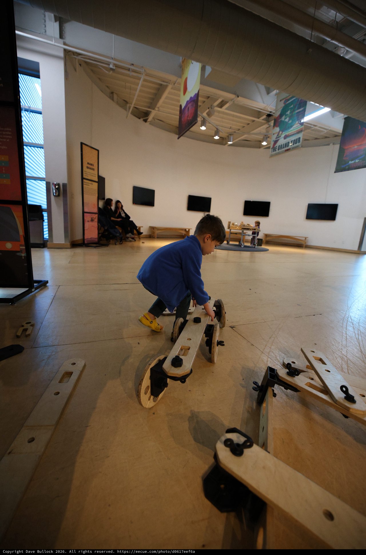 Child Playing with Wooden Construction Toy in Museum Gallery