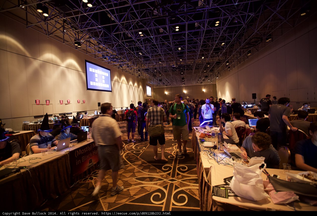 Defcon 22 Techies at Work Caption: A crowded cafeteria in Las Vegas filled with tech-savvy people engrossed in coding and networking activities during Defcon 22.