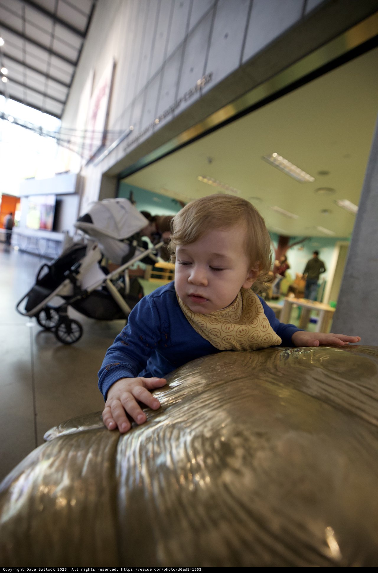 Young Child Exploring Bronze Sculpture at Museum