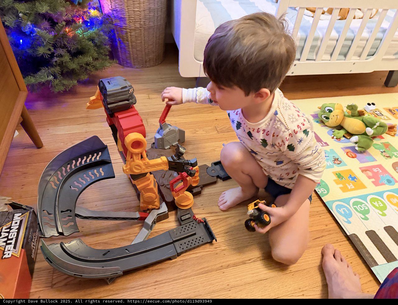 Toddler Playing with Monster Truck Toy Track Set at Christmas