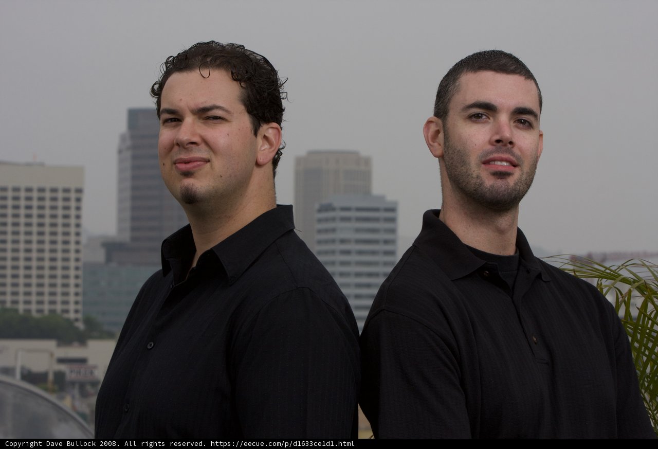 Two Men Smiling in Front of a Skyscraper