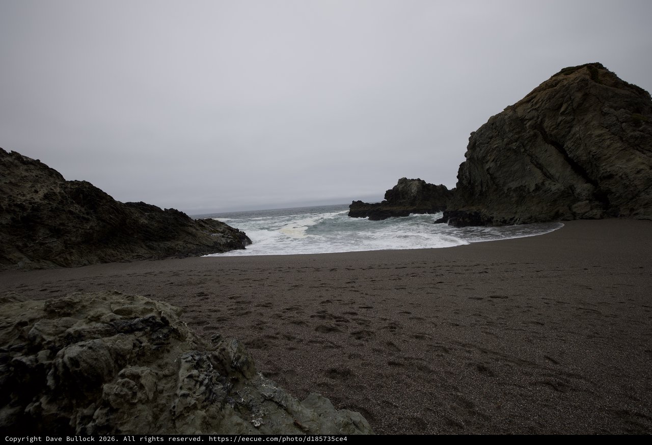 Rugged Cove Where Dark Sand Meets Crashing Pacific Waves