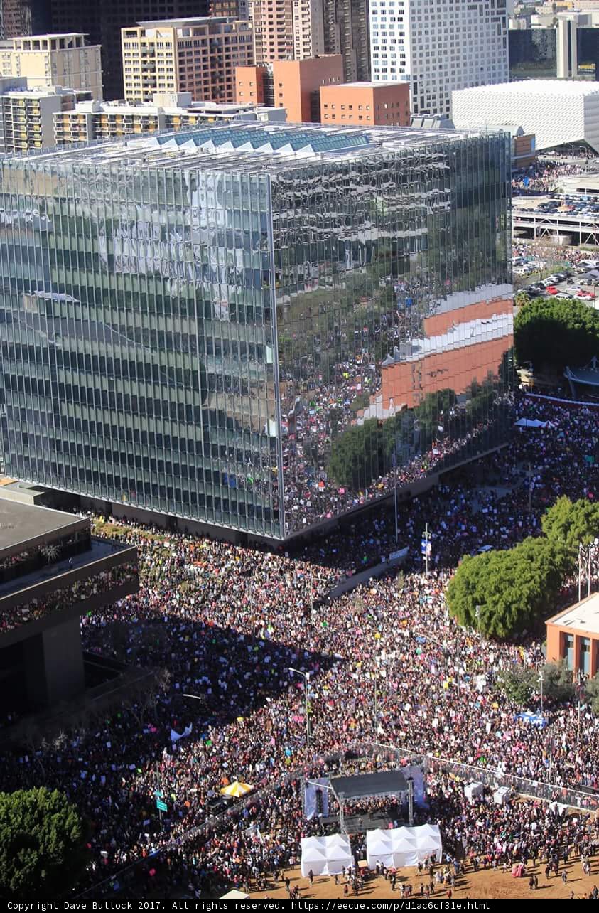 City Crowd Gathers in Front of Three Buildings