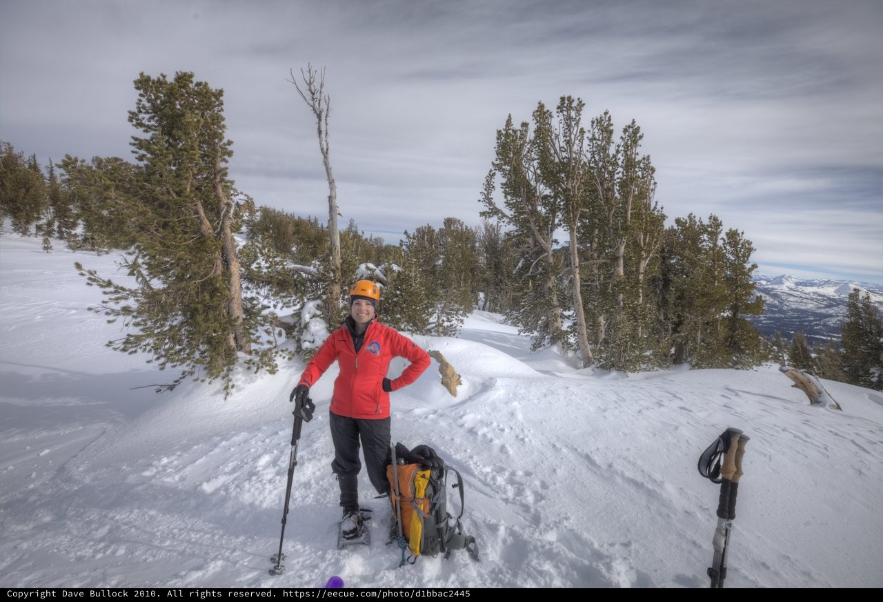 Smiling Mountaineer Rests Atop Snowy Sierra Summit