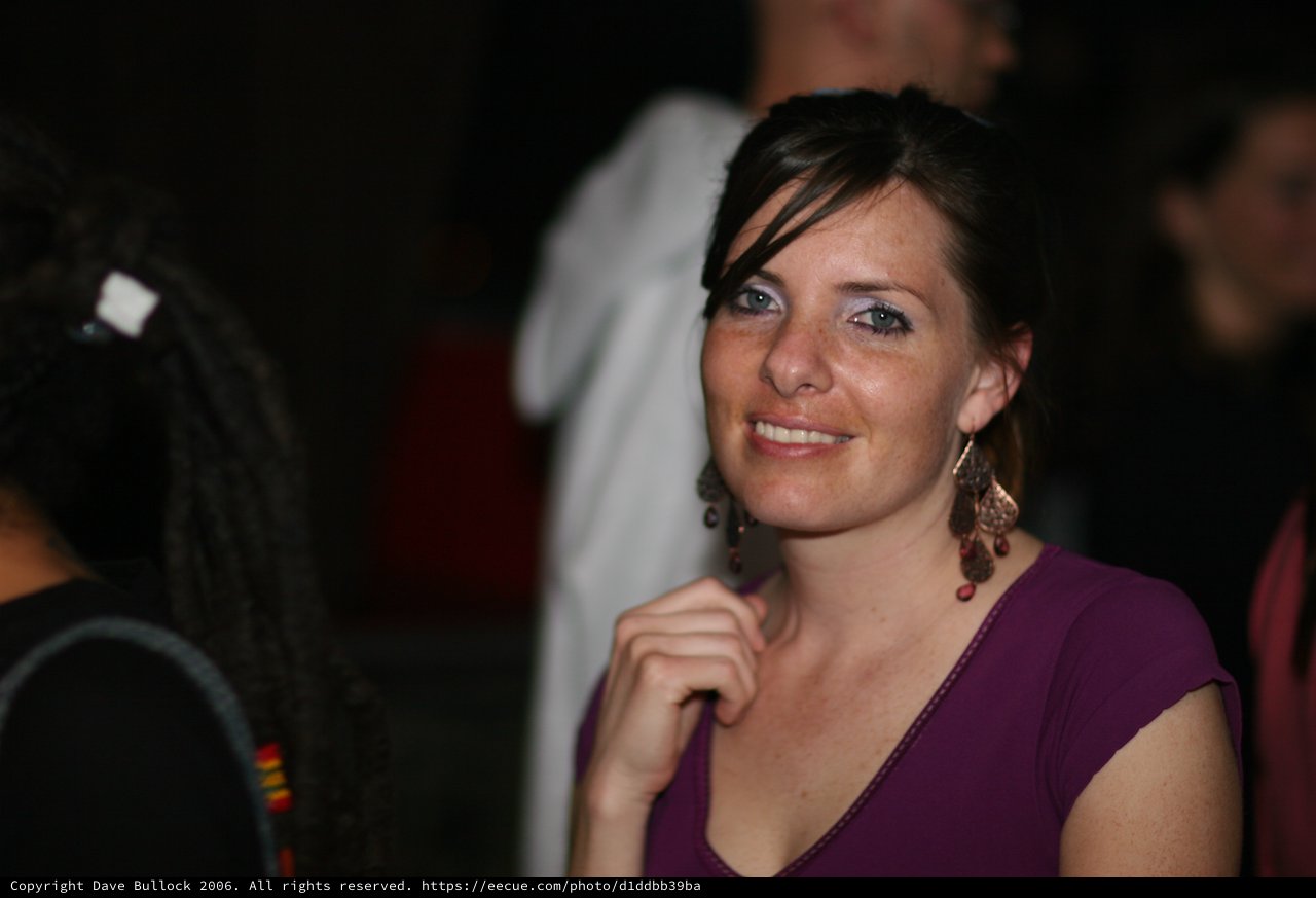 Smiling Woman in Purple at Evening Social Event