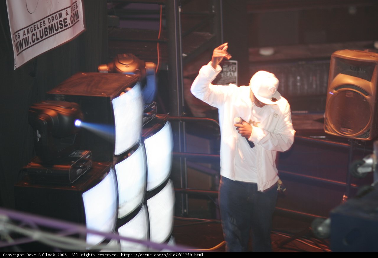 Man on Stage with White Shirt and Hat
