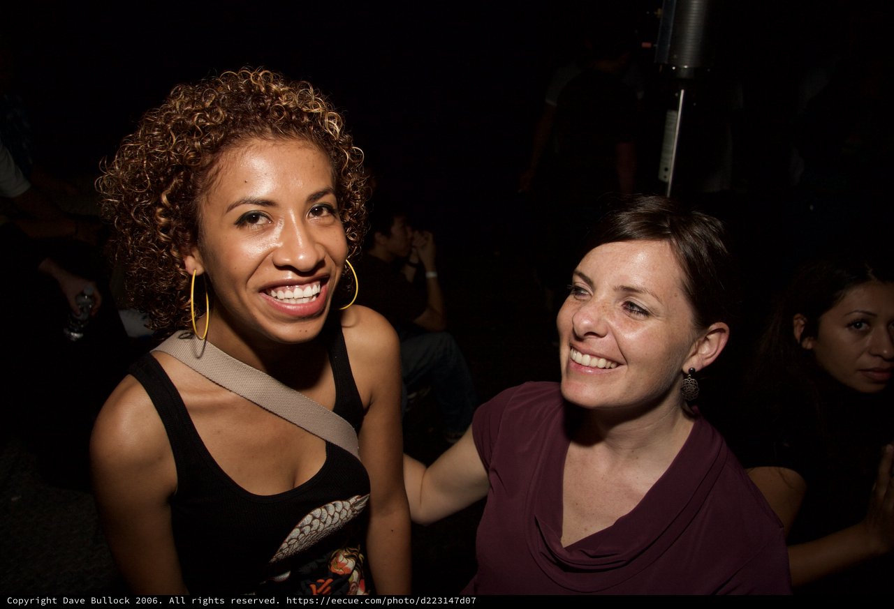 Two Women Smiling Together at Nightclub Event