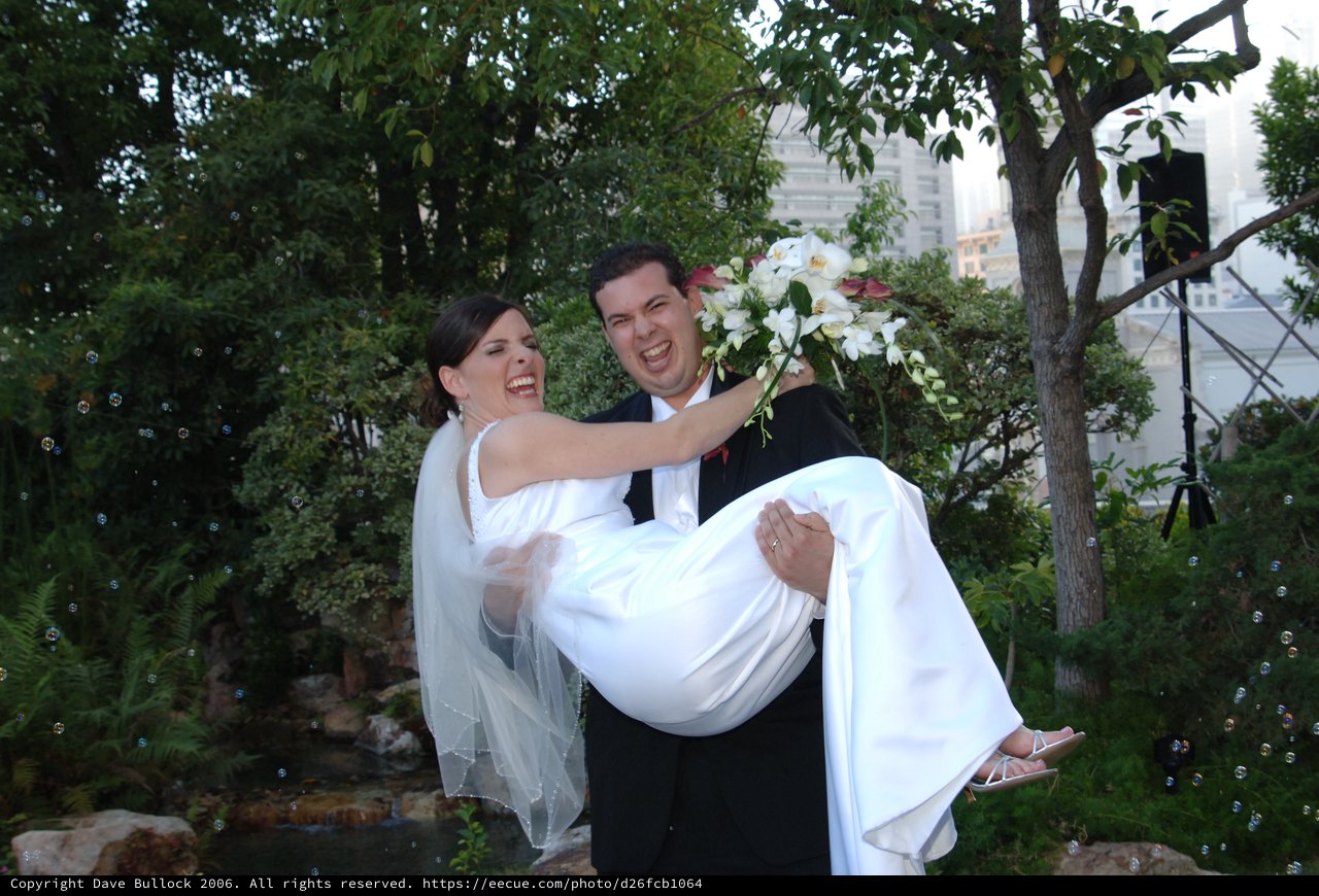 Joyful Groom Carries Laughing Bride on Wedding Day
