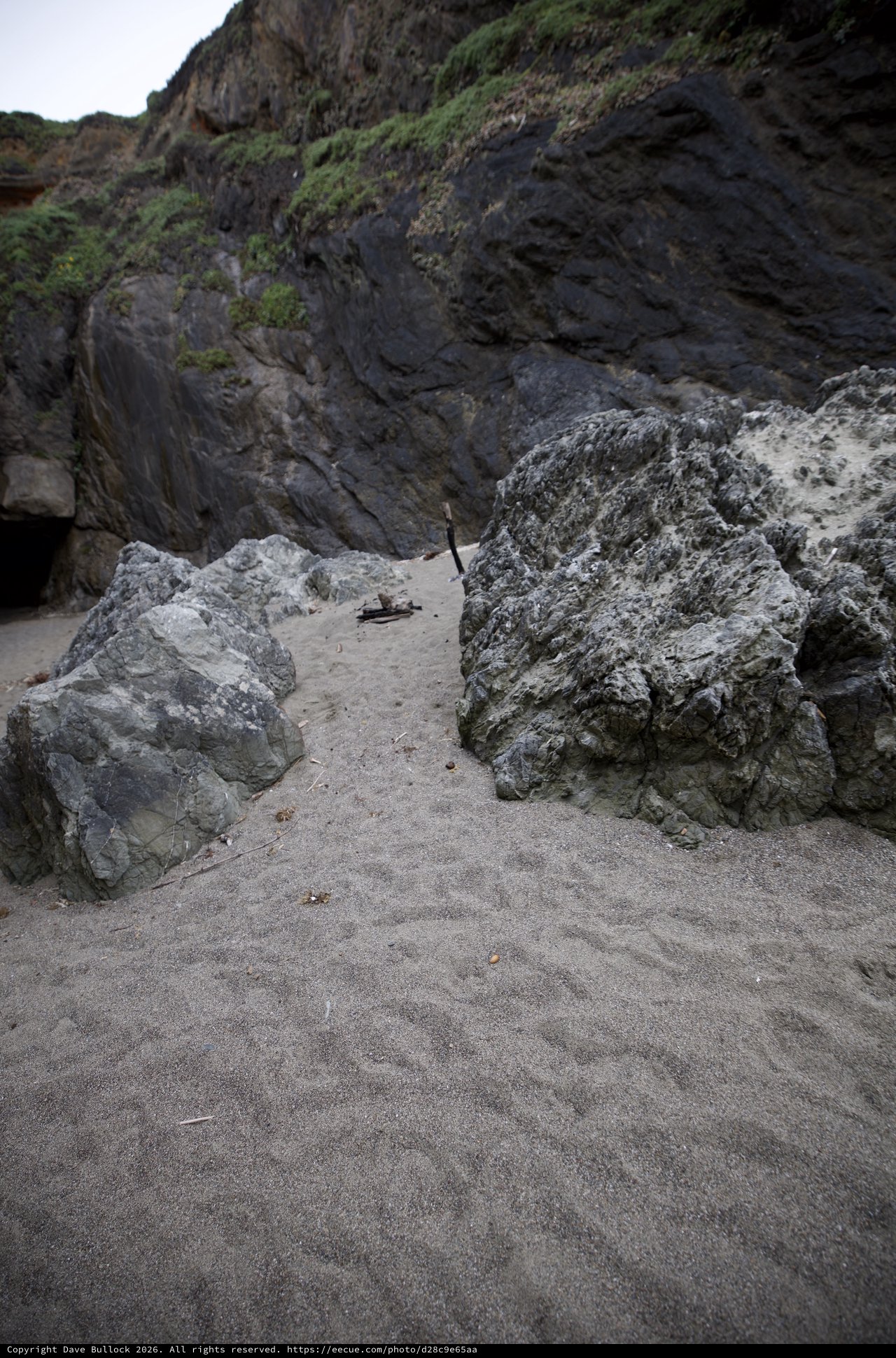 Dark Coastal Cliffs Frame Sandy Cove Passage