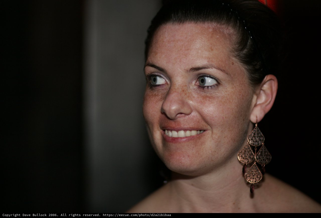 Radiant Woman with Freckles and Chandelier Earrings