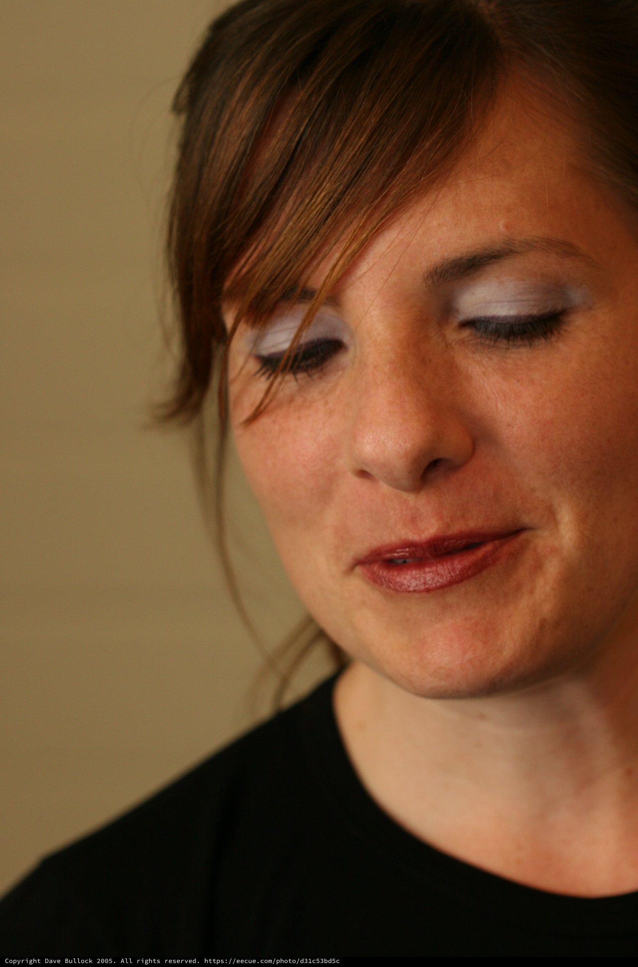 Contemplative Woman With Bold Eye Shadow Looks Down