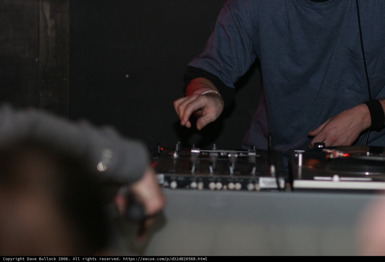 Blue Shirted DJ Spinning His Tracks