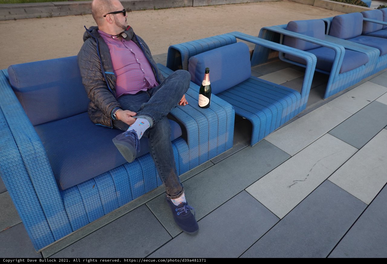 Man Relaxing with Champagne on Blue Furniture