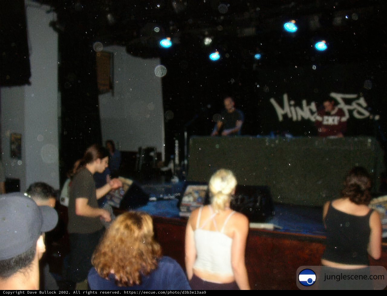 Nightclub Crowd Gathers Around DJ on Stage