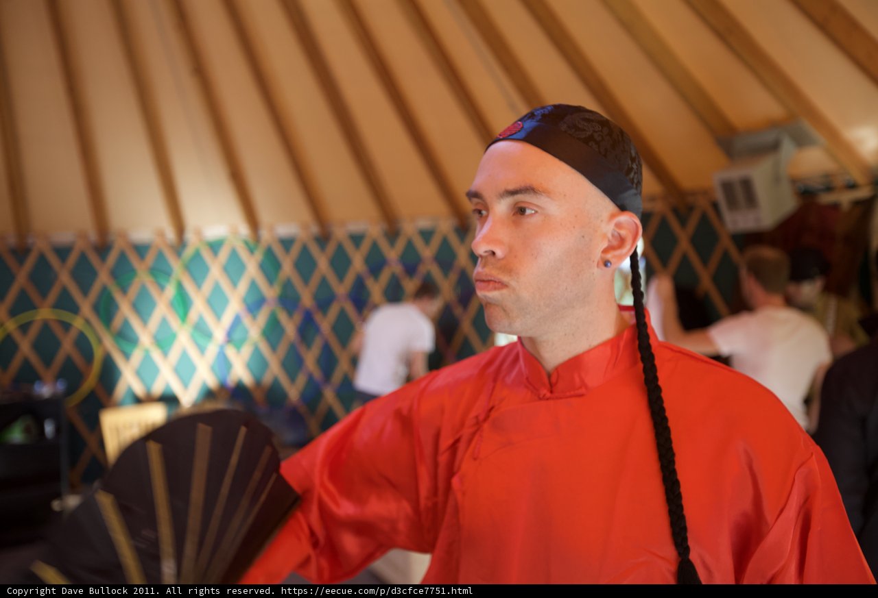 Man in Red Outfit Poses in Front of Yurt