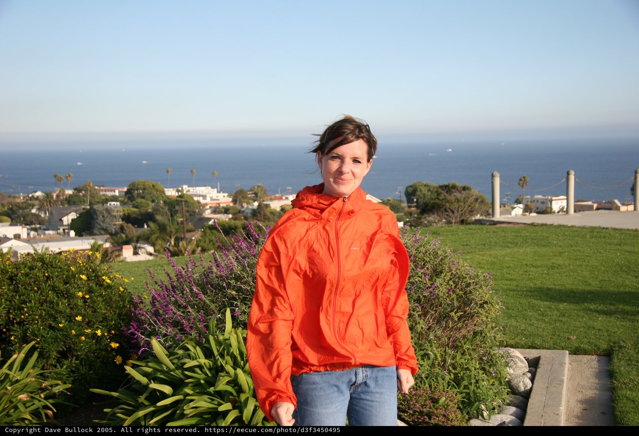 Woman in Orange Jacket Overlooking California Coastal Town