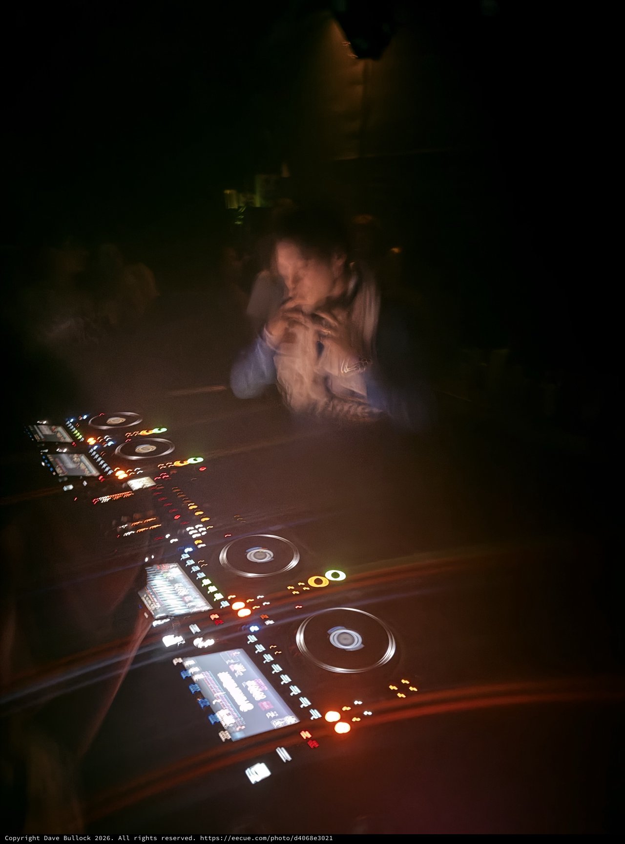 DJ Performance in Dark Club with Illuminated Controllers
