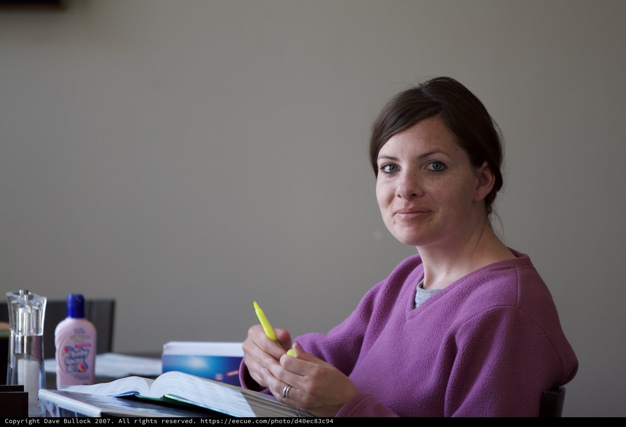 Woman Studying with Yellow Pen at Desk