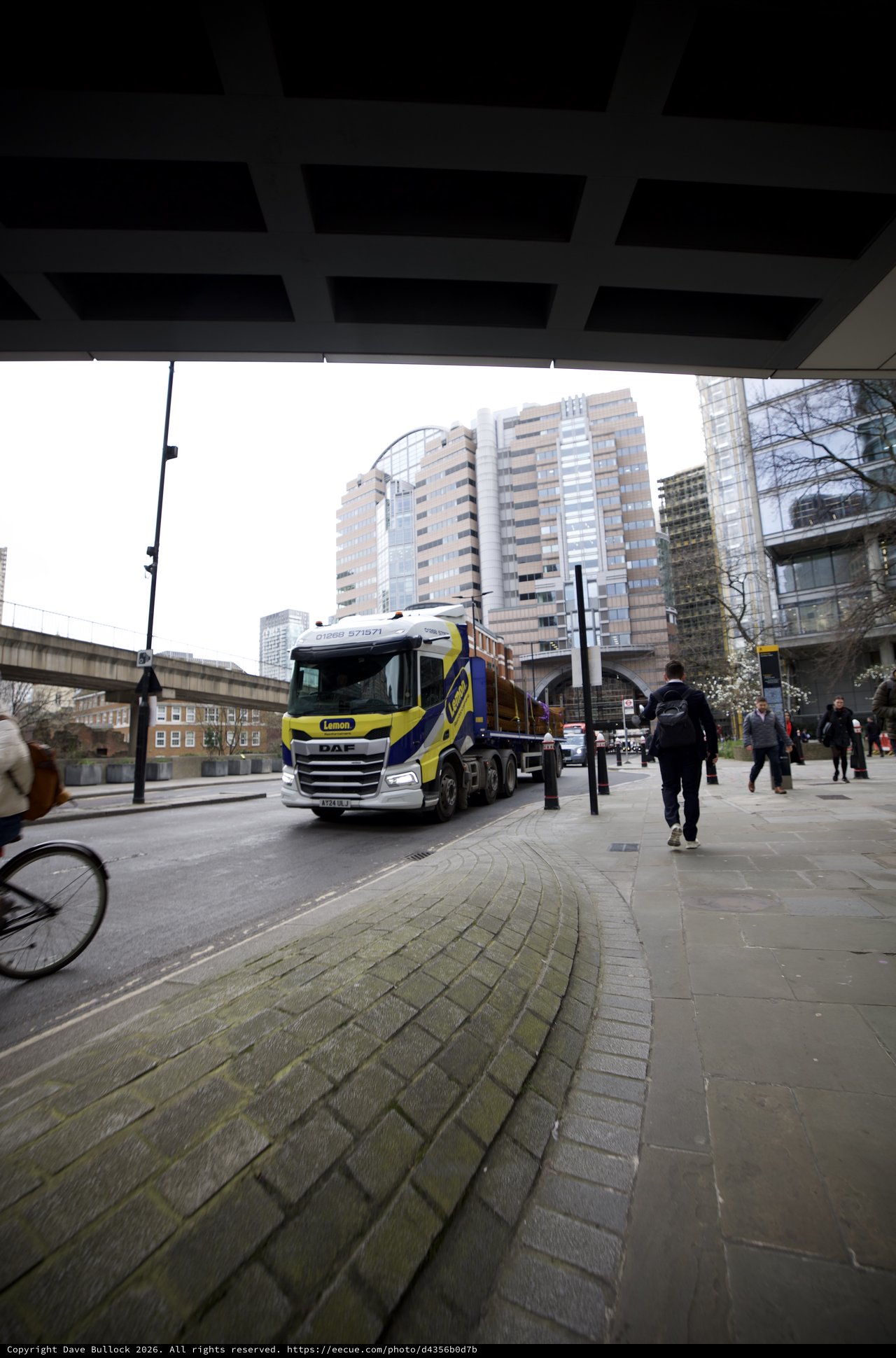 Heavy Truck Navigating Under Modern Urban Bridge