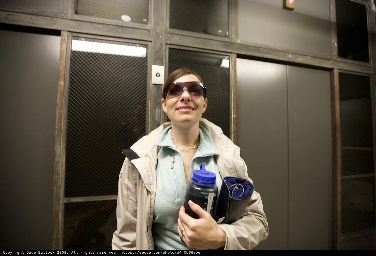 Woman With Water Bottle Smiles Near Lockers