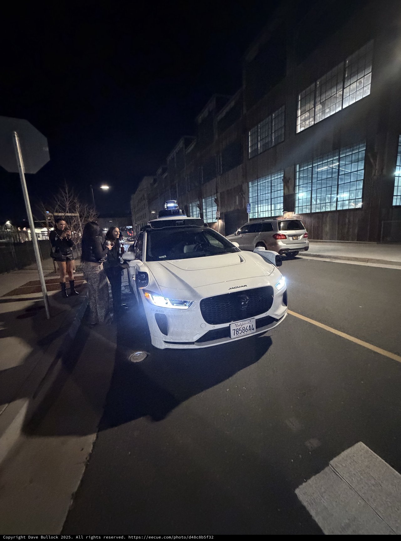 Autonomous Jaguar I-PACE at Night with Onlookers