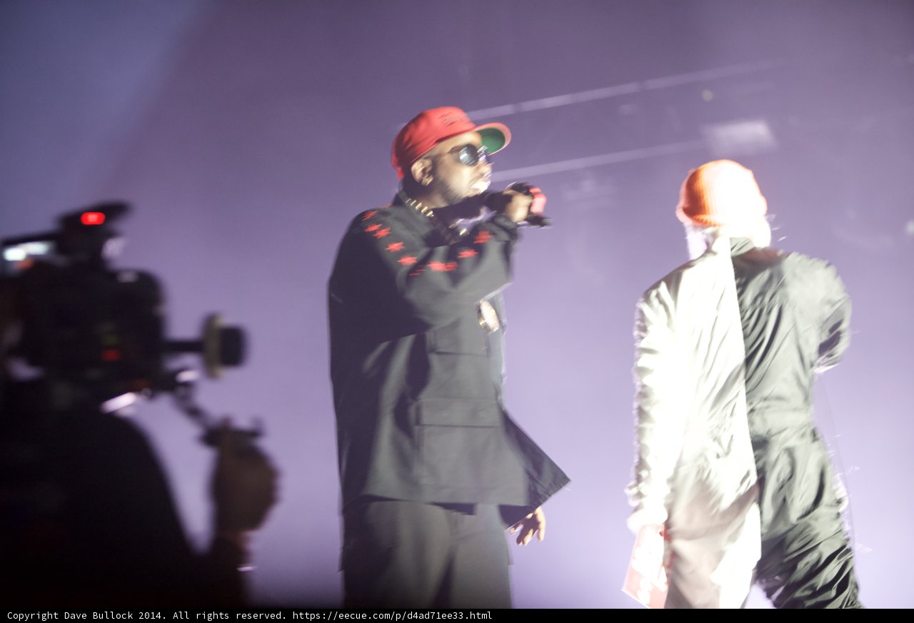 Two Men in Black Suits and Red Hats Perform on Stage