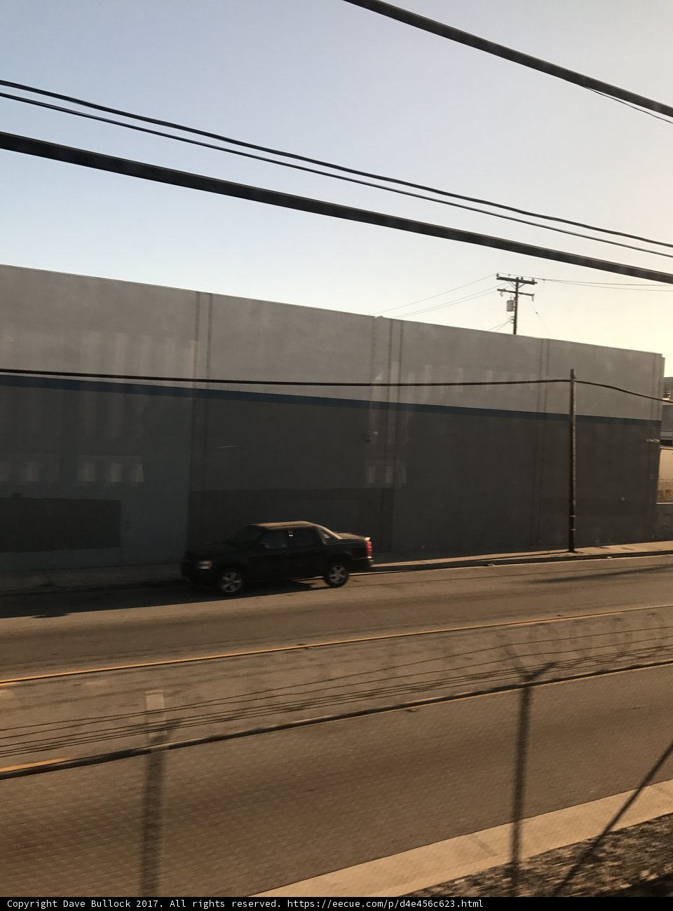 A Car Speeds Down the Road Near a City Building