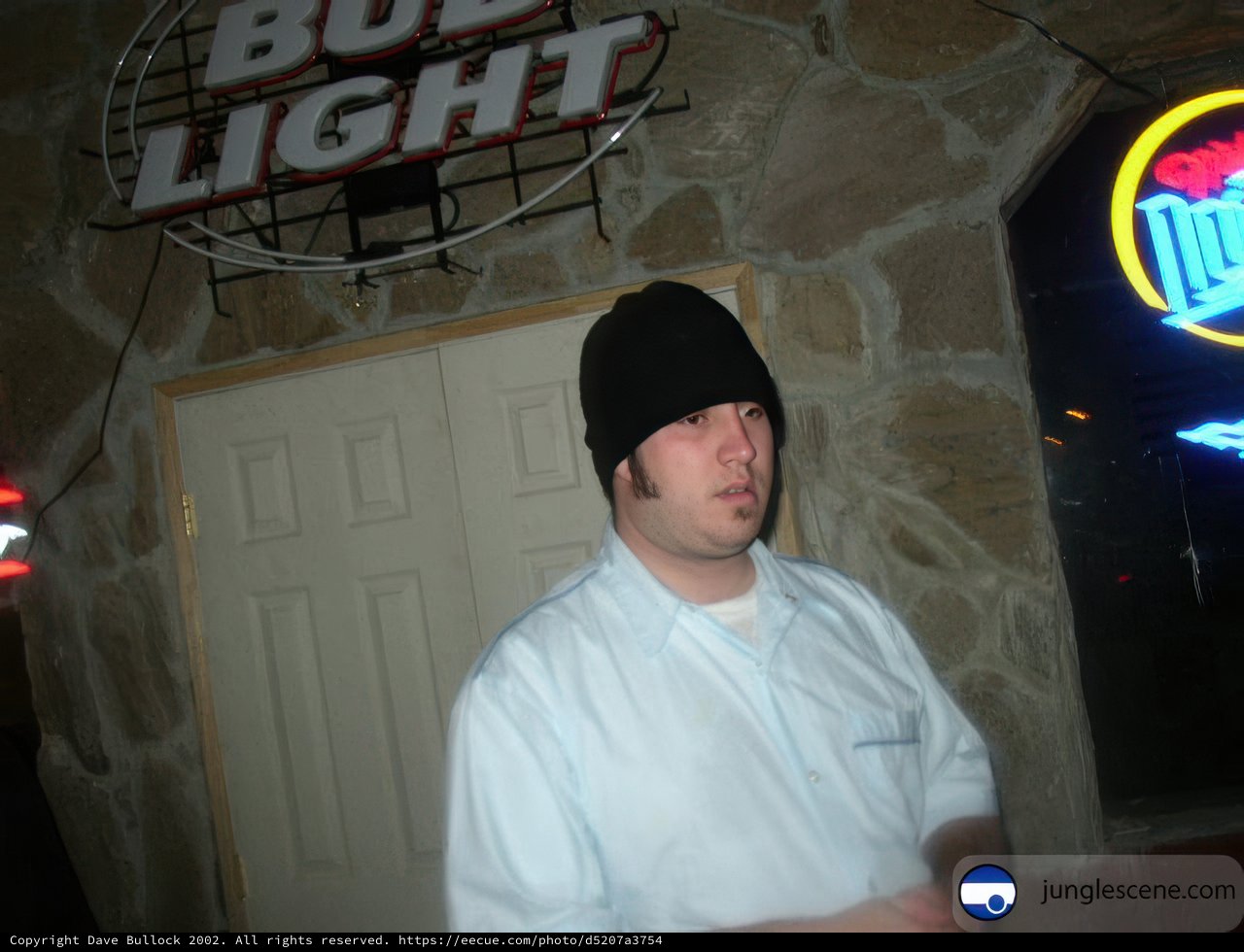 Man in Beanie Stands Before Sign