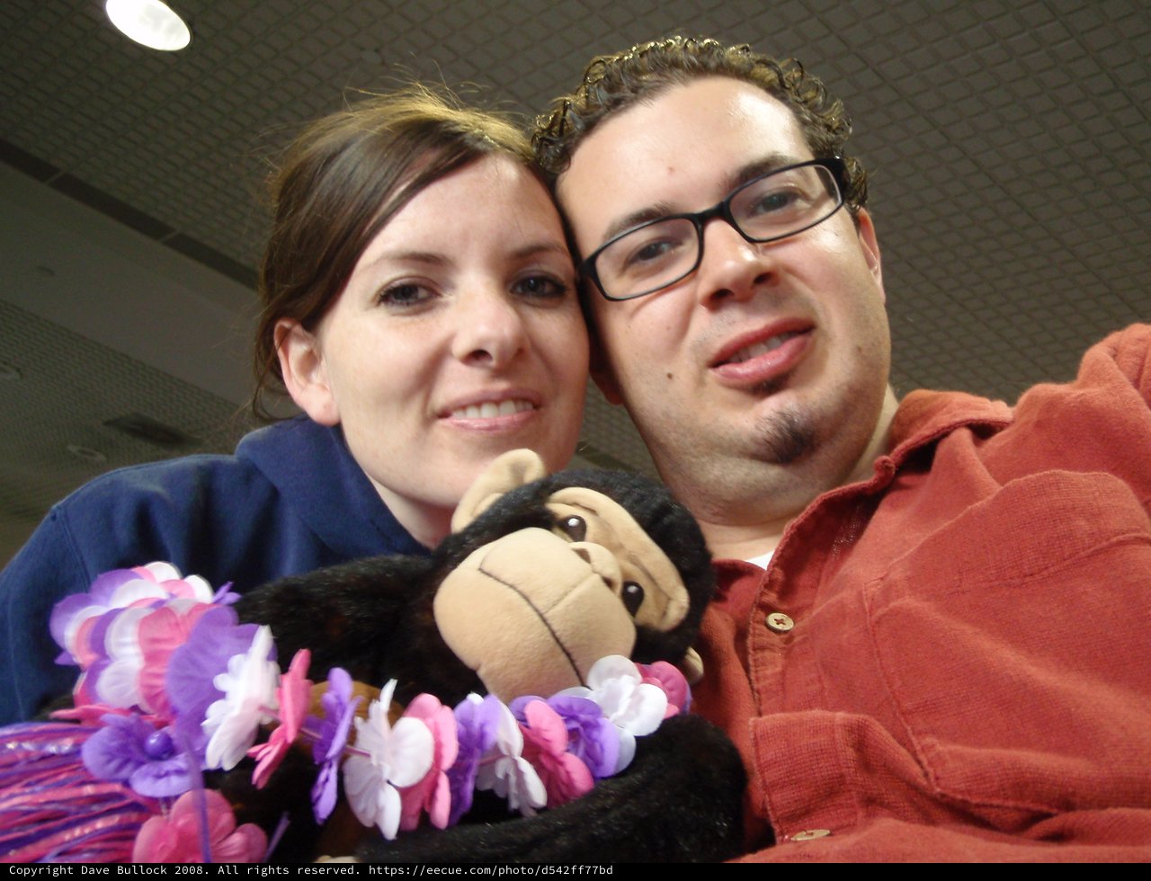 Couple with Lei-Wearing Monkey Plush at Airport