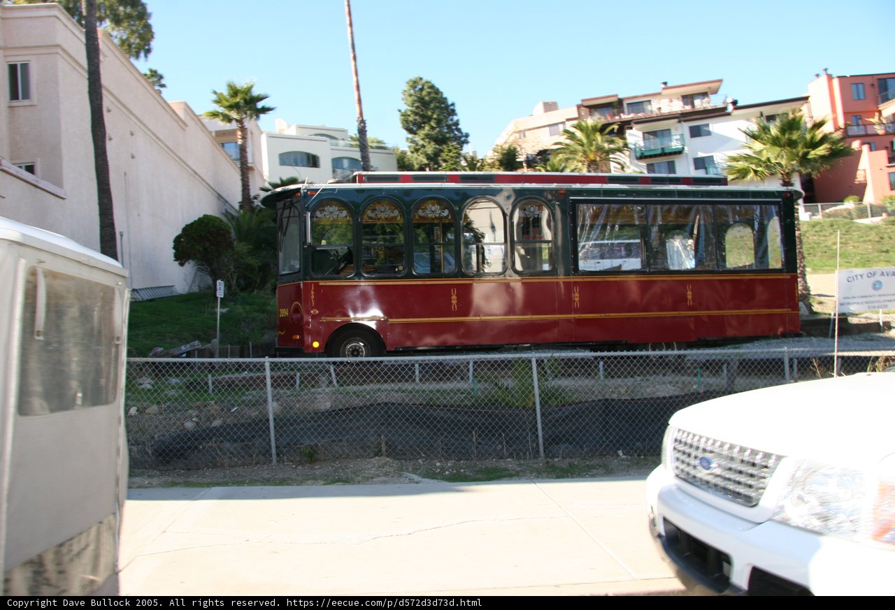Red and White Trolley Car Parked on the Side of the Road