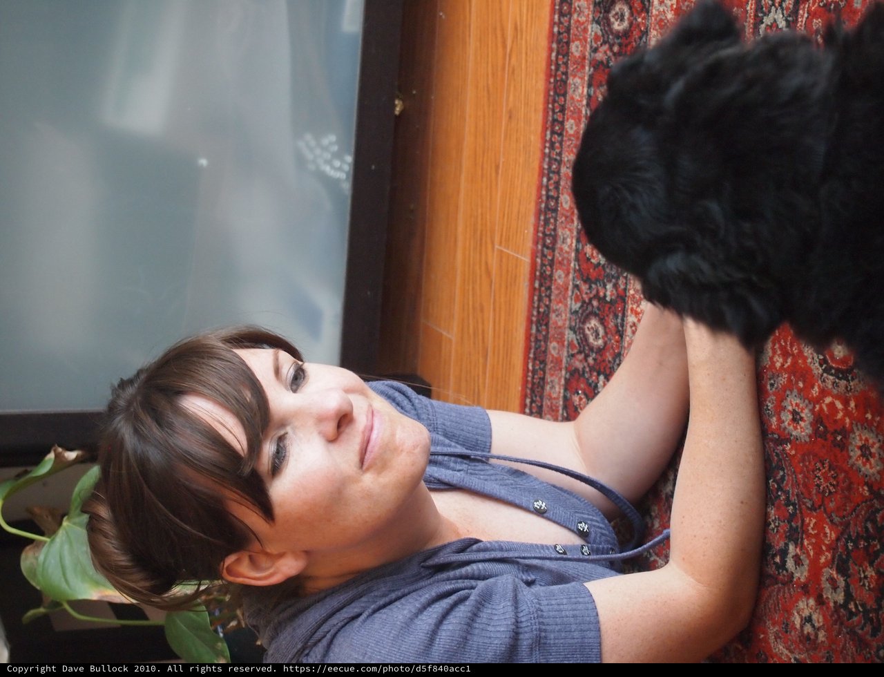 Woman Relaxing on Floor with Black Dog