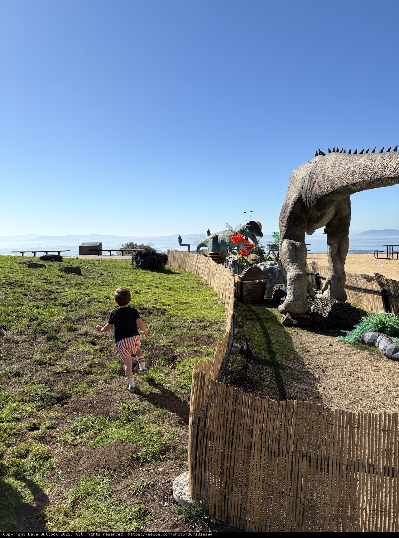 Child Encounters Giant Dinosaur at Beachside Park