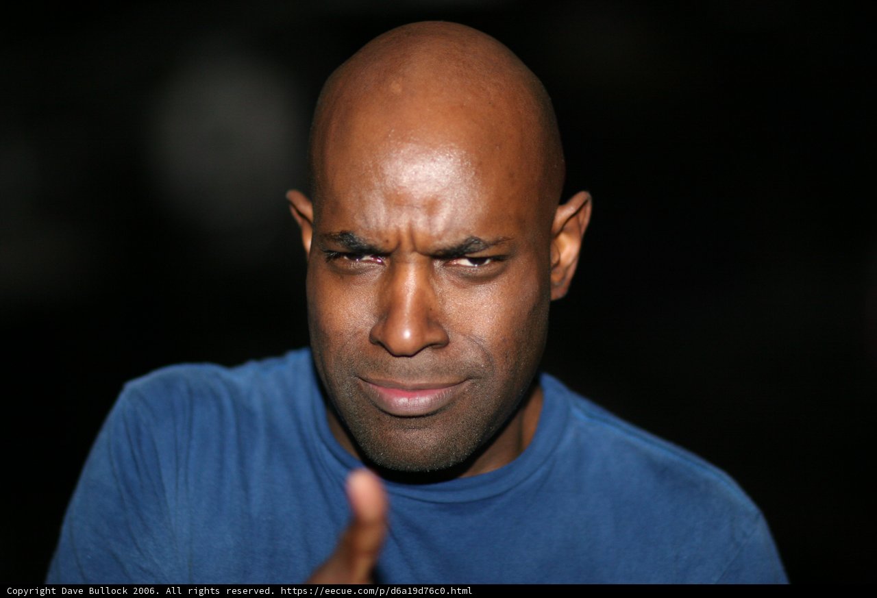 Bald Man Gesturing in Blue