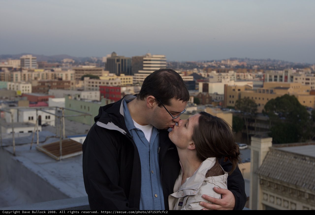 Rooftop Kiss Against Urban City Skyline