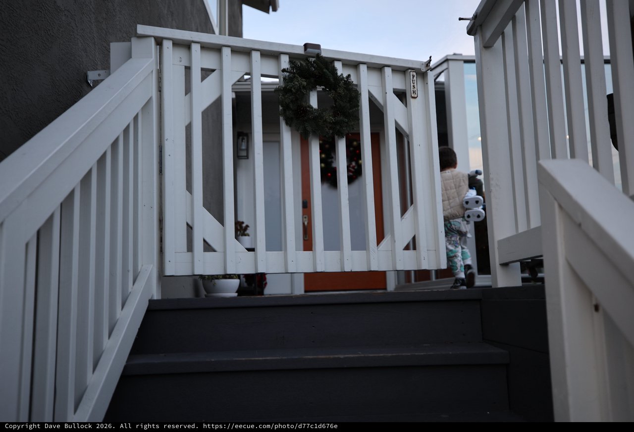Child on Winter Deck with Holiday Wreath