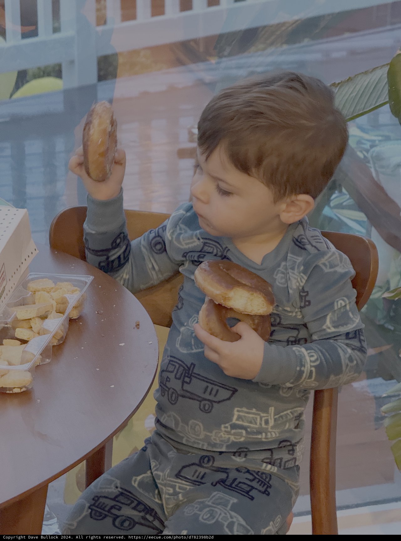 Toddler Enjoying Donuts at Kitchen Table