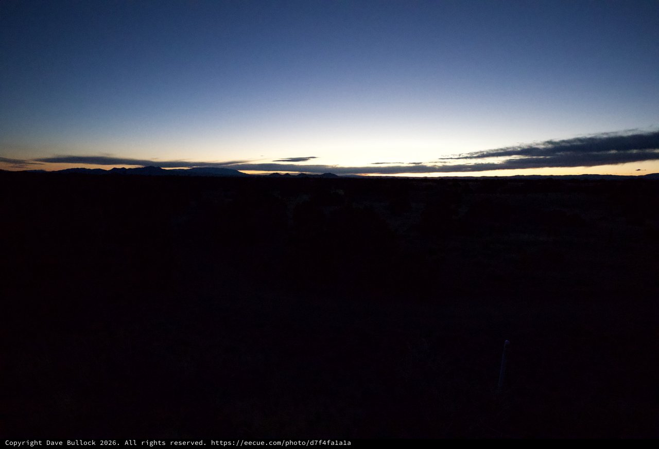 Desert Twilight Over Distant Mountain Silhouettes