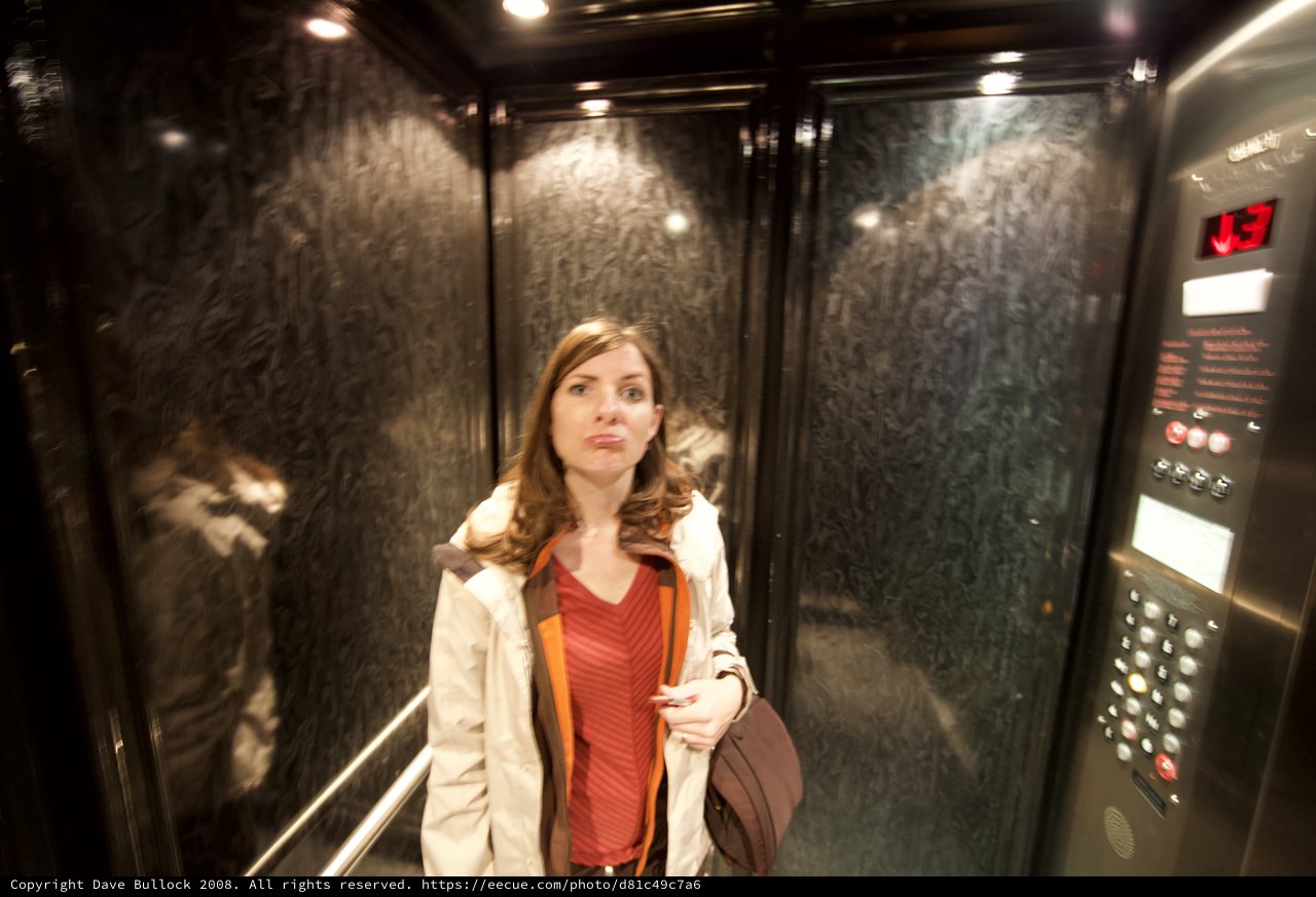 Woman Makes Funny Face in Dark Elevator