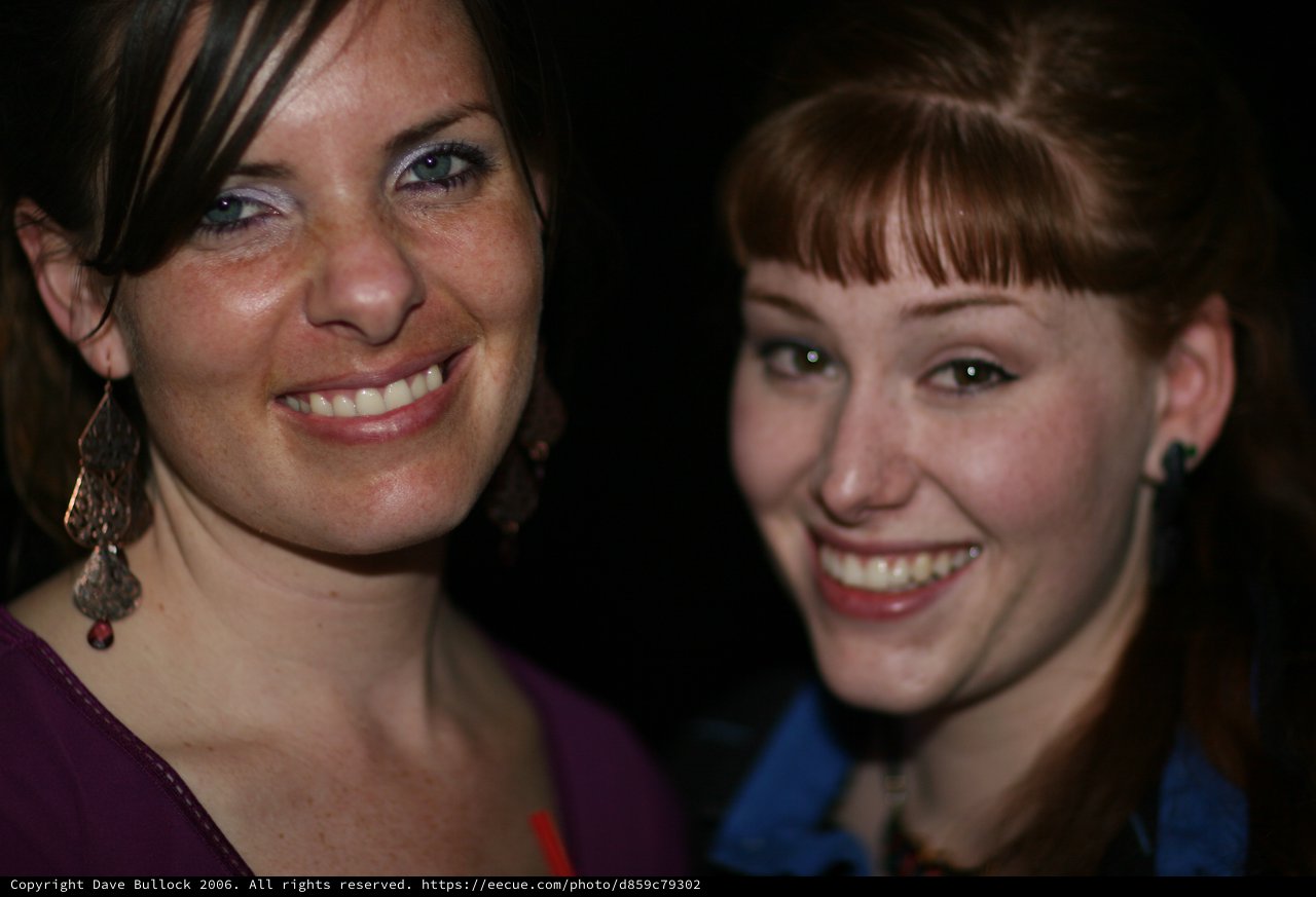 Two Smiling Women Posing Together at Night Event