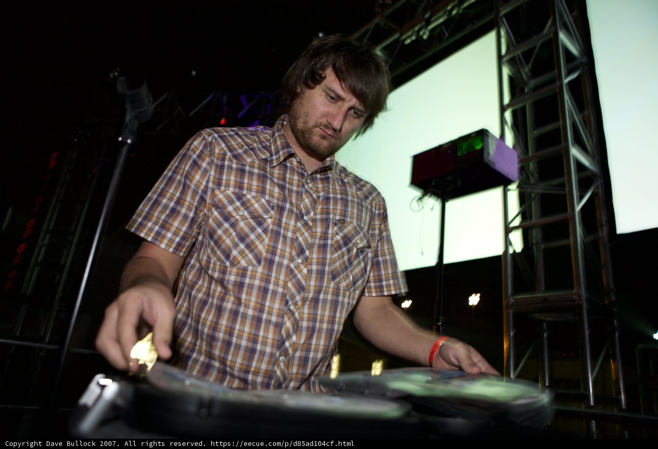 Man in Plaid Entertains Crowd with DJ Set