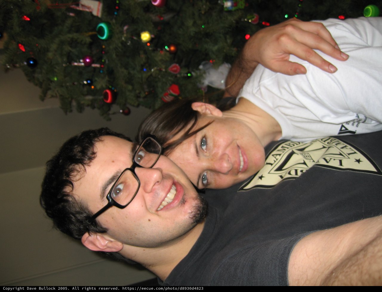 Holiday Cheer: Couple Poses by Christmas Tree
