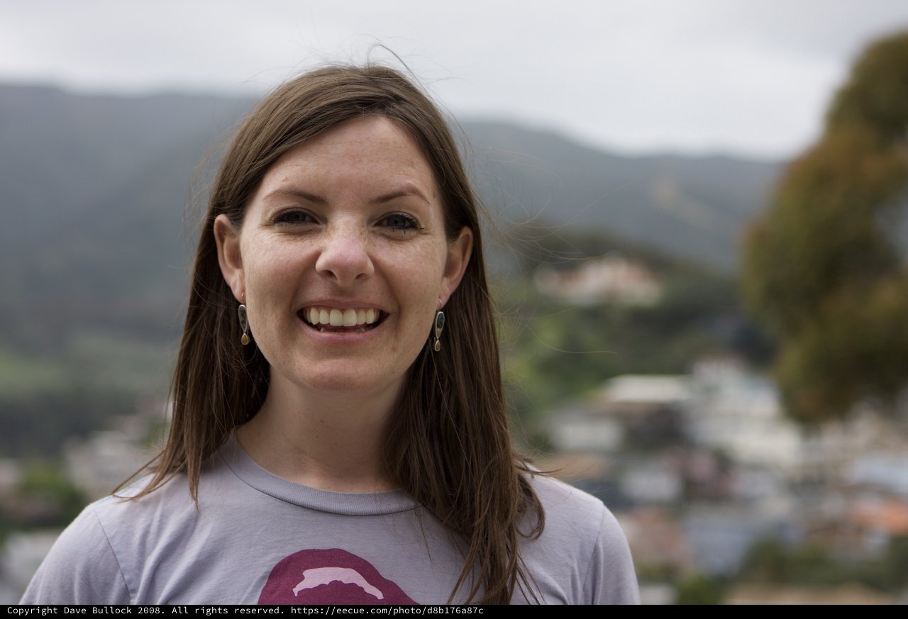 Smiling Woman Portrait Against Mountain Town Backdrop