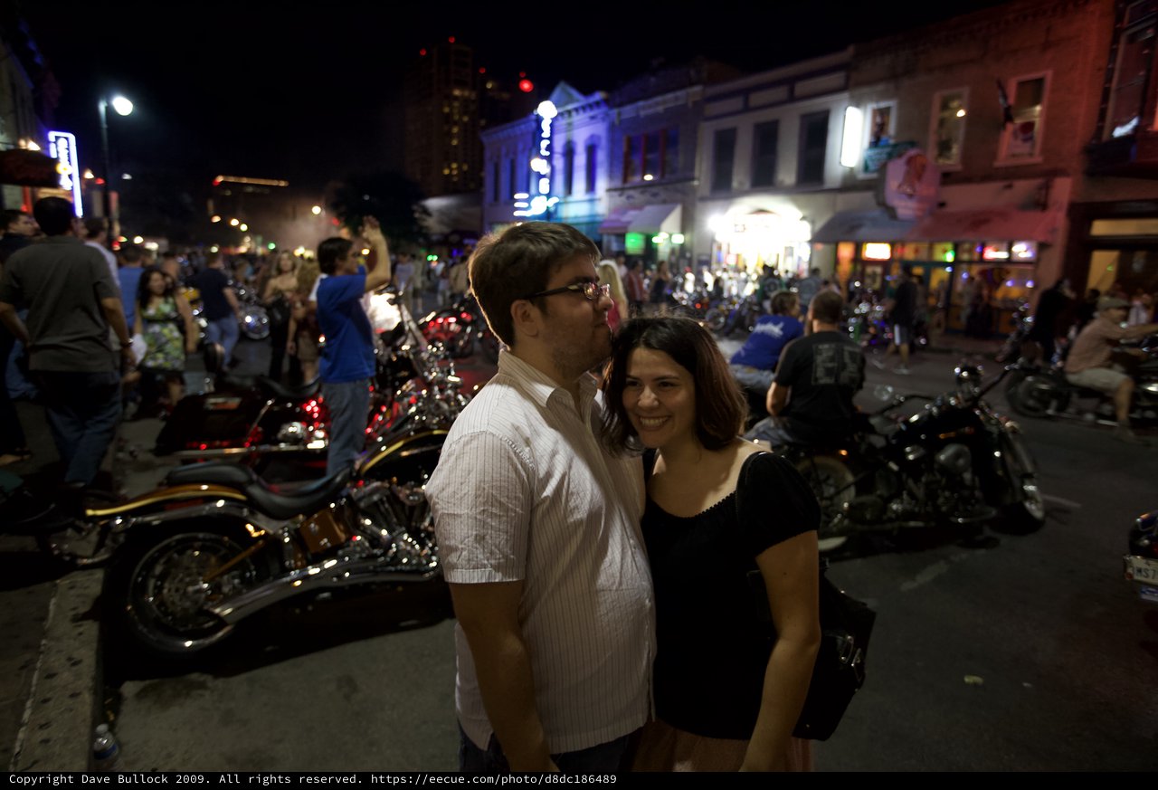 Couple Embracing on Lively Austin Street at Night