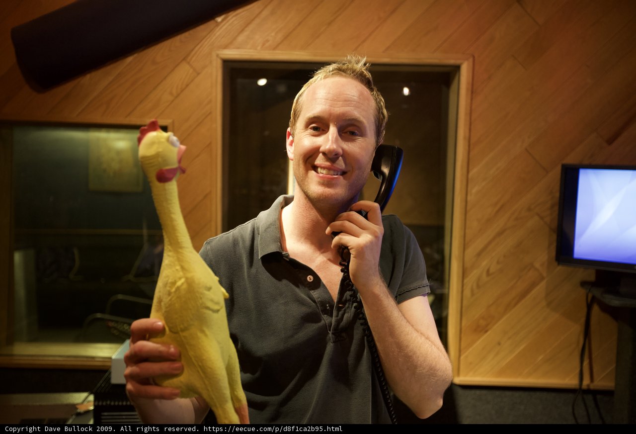 Man and Chicken Toy at the Microphone