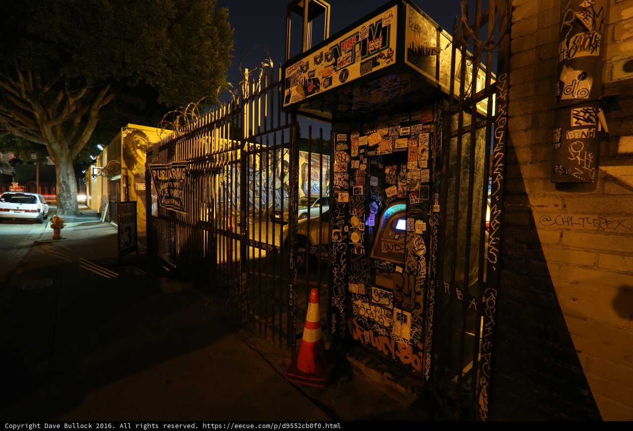 Graffiti on a City Phone Booth at Night
