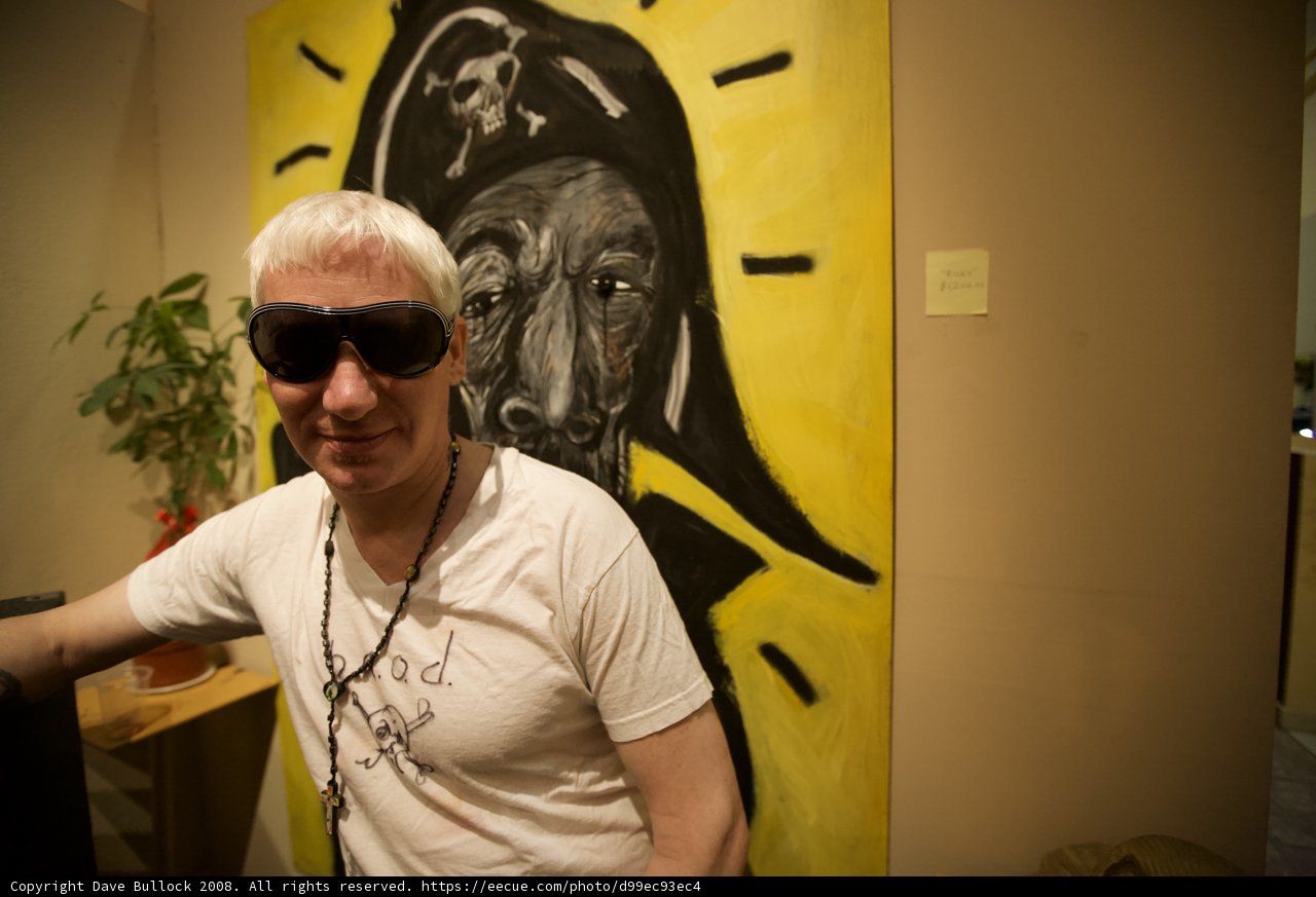 Man in Sunglasses Poses in Front of Artwork