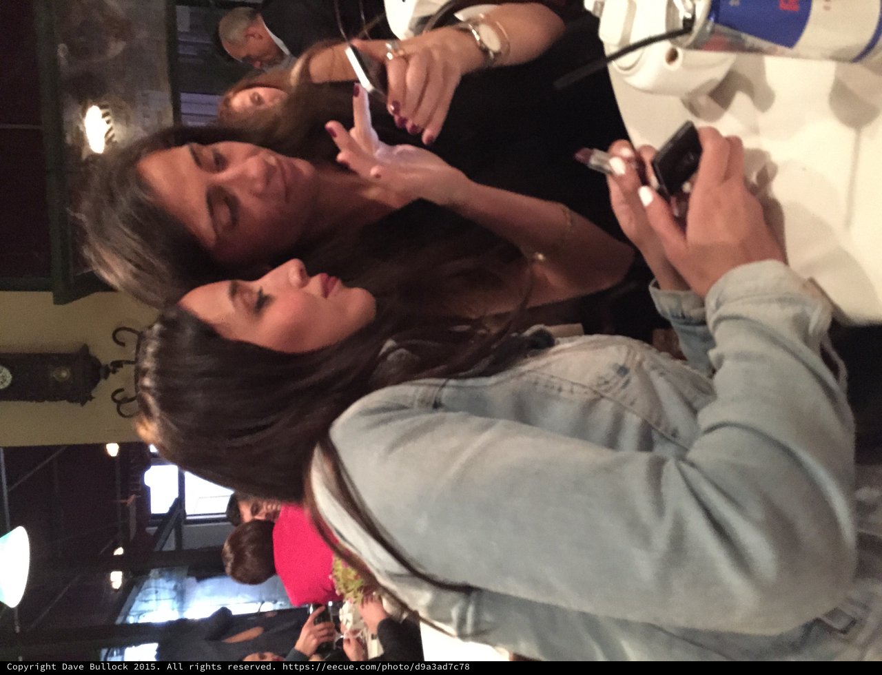 Two Women Share a Moment Over Phones at Restaurant