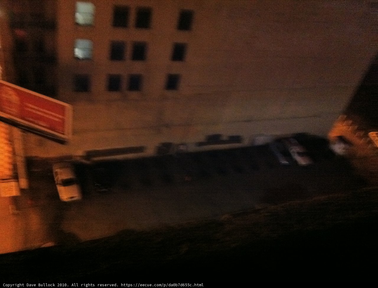 Nighttime View of a City Parking Lot from an Apartment Window