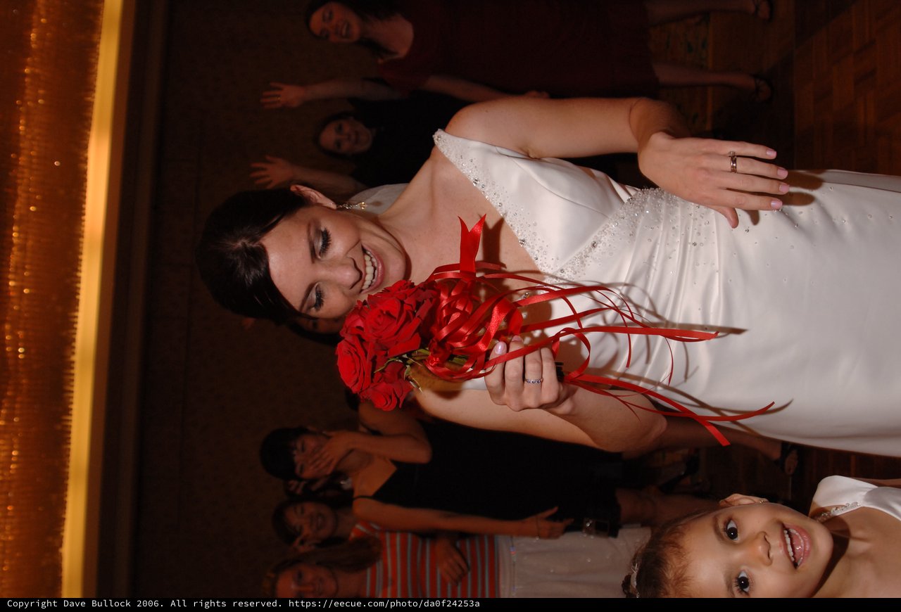Bride Laughs While Clutching Red Rose Bouquet